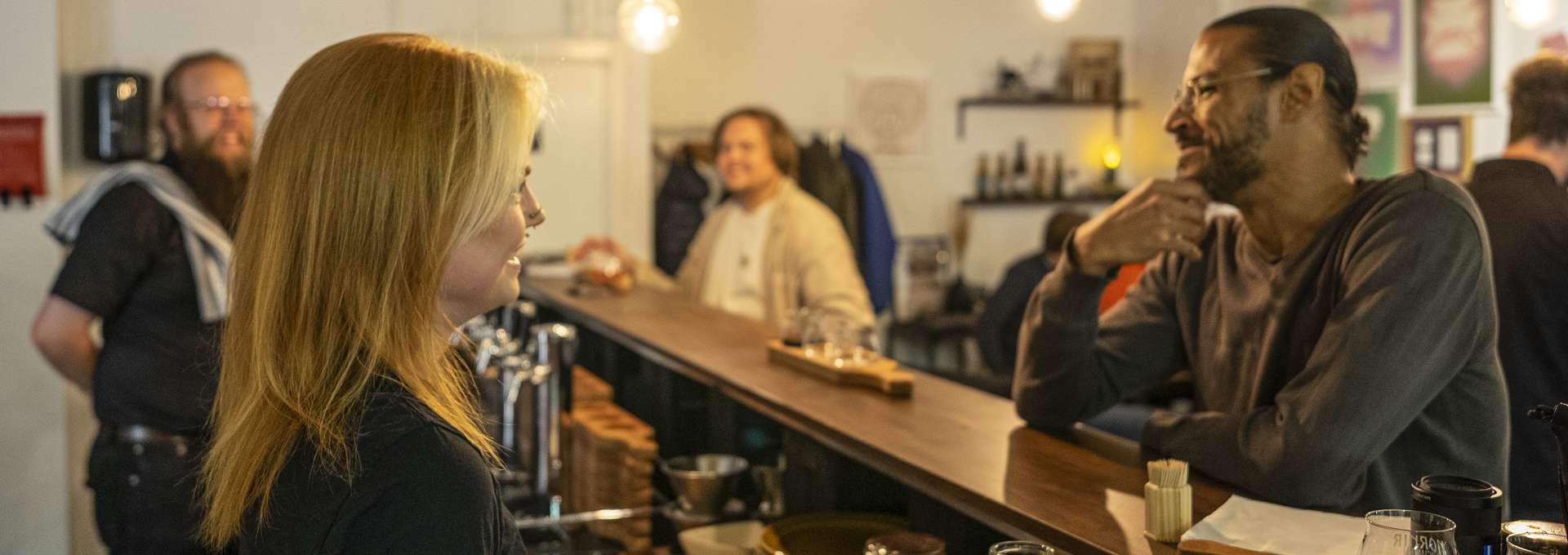 En bardisk där en man pratar med en kvinnlig bartender.