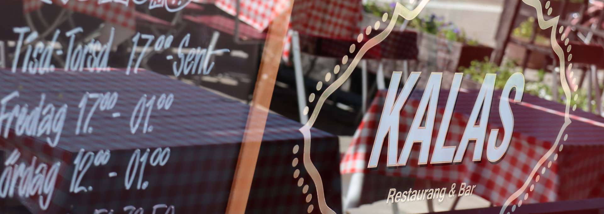 närbild på ett skyltfönster med texten Kalas restaurang & bar på
